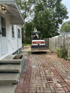 An excavator on a residential site for demolition and debris removal by Black Diamond Junk Removal in Bedford Heights, OH.