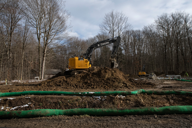 A large excavator performing site preparation with erosion control measures by Wilkinson Excavating, Inc. in Meadville, PA