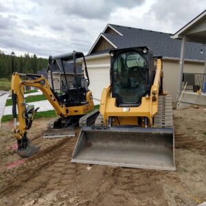 A mini excavator and a skid steer loader parked at a residential construction site by Aspen Excavation in Spokane, WA.