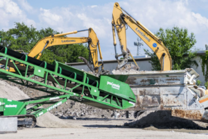 Excavators loading construction debris onto a conveyor belt system at Global Recycling of Tampa Bay in Tampa, FL.