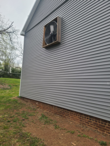 Large exhaust fan installation on a building with gray siding by Jos Construction LLC in Trenton, NJ.