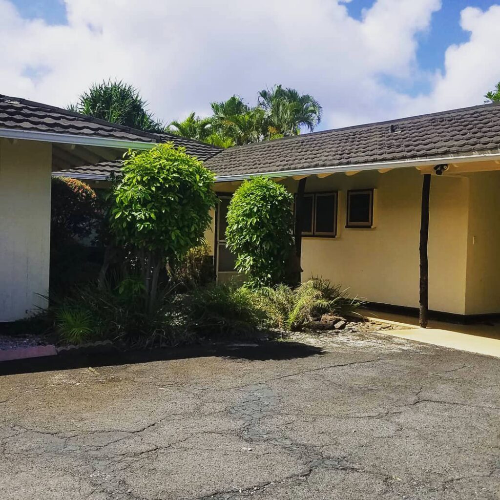 Two expertly trimmed columnar trees in front of a home by McShane Maintenance Yard Services in Waipahu, HI