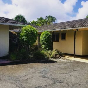 Two expertly trimmed columnar trees in front of a home by McShane Maintenance Yard Services in Waipahu, HI