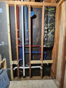 An exposed wall showing new PEX plumbing pipe installation by AJAC Restore&Construct LLC in Houma, LA.