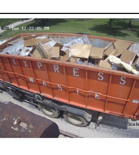 An overhead view of a full Express Waste orange dumpster ready for pickup in Denham Springs, LA.