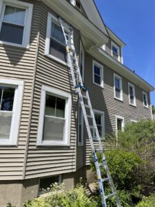 A tall extension ladder leaning against a house, ready for handyman work by Triple M Handyman in Portsmouth, NH.