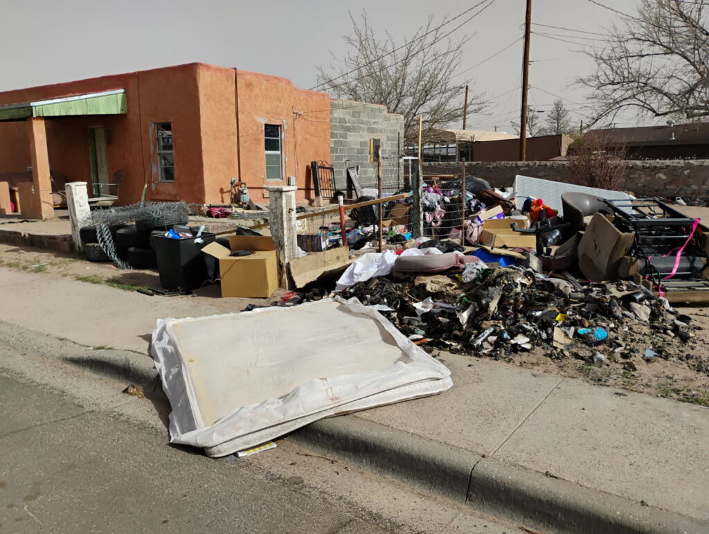 An extensive pile of mixed junk, including a mattress and various debris, outside a house for cleanout by Discount Hauling in Las Cruces, NM.