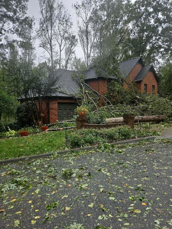 Extensive storm damage with multiple fallen trees on a house and driveway, handled by Rapid Response Crew in Charlotte, NC.