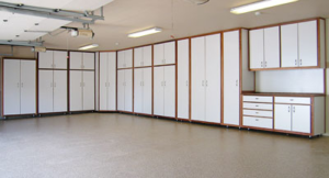 An extensive white garage cabinet system with brown trim, tall storage, and base cabinets installed by NW Garage Cabinet Company in Ridgefield, WA.