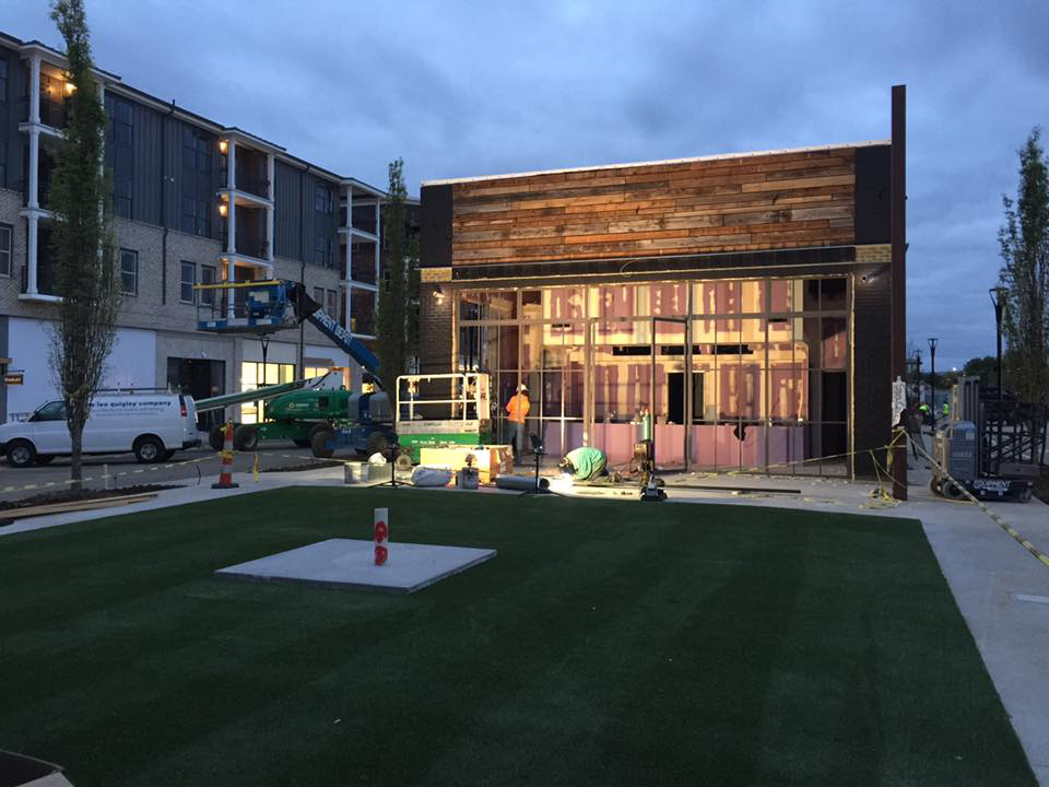 An exterior building renovation project in progress by Recreated in Birmingham, AL, with workers and equipment.
