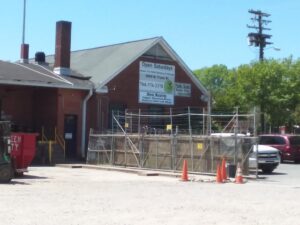 The exterior of Queen City Metal Recycling & Salvage building with signs indicating scrap buying services in Charlotte, NC.