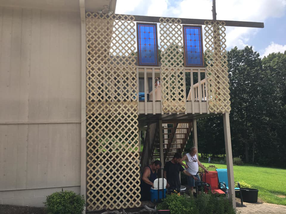 Exterior view of a home with new deck lattice and decorative panels being installed by Calkins Cabinetry/Handyman's Services in Bentonville, AR.