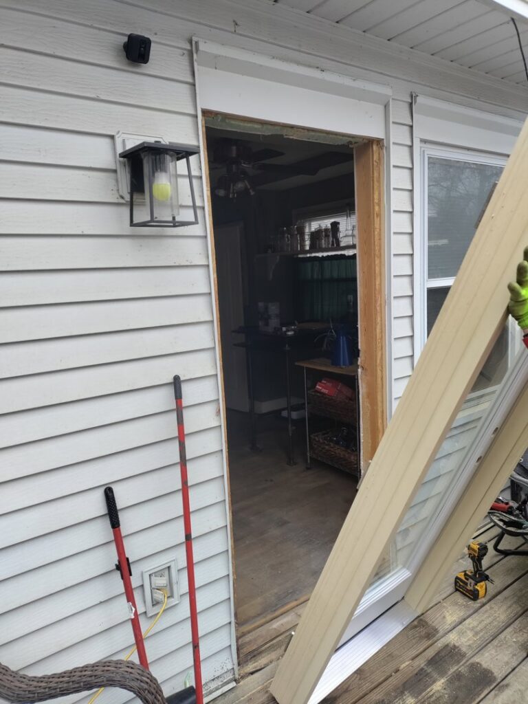 An exterior door frame being installed or repaired on a house with siding, a service provided by Homefix Lawrence in Lawrence, KS.