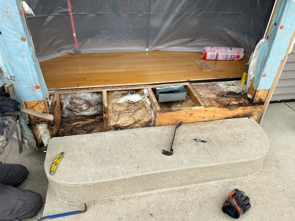 Exterior door frame repair and demolition showing exposed subfloor and insulation by Silhouette Builders, Inc. in Yorkville, IL
