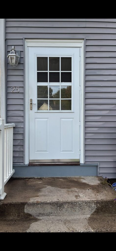 A newly installed white exterior door with glass panels by Class General Contracting in West Springfield, MA.