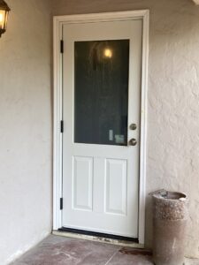 A newly installed white exterior door with a glass panel, showcasing door installation services by Absolute Integrity Handyman Services Inc in Fresno, CA.