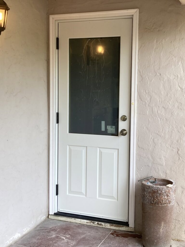 A newly installed white exterior door with a glass panel, showcasing door installation services by Absolute Integrity Handyman Services Inc in Fresno, CA.