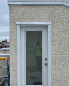 A newly installed white exterior door on a textured building wall by MCG General Contractor in Philadelphia, PA.