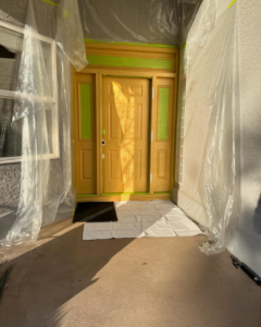 An exterior front door being painted, protected by plastic sheeting, by Syd's Handyman Services in Oxnard, CA.