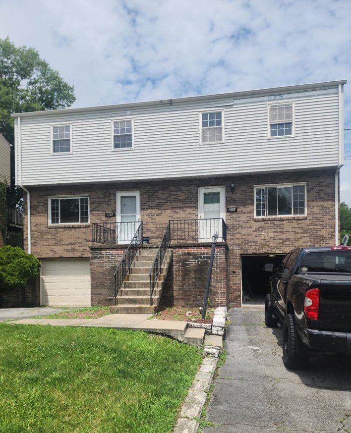 An exterior view of a renovated duplex building, showcasing general contractor work by Brush: A Professional Painting Company in Pittsburgh, PA.