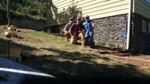 Handymen from Element Construction Company performing exterior foundation work on a home in Colorado Springs, CO.