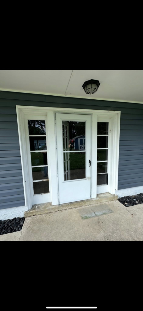 Exterior view of a newly installed front entry door with side panels and an overhead light, completed by CNG Contracting Group in Richmond, VA