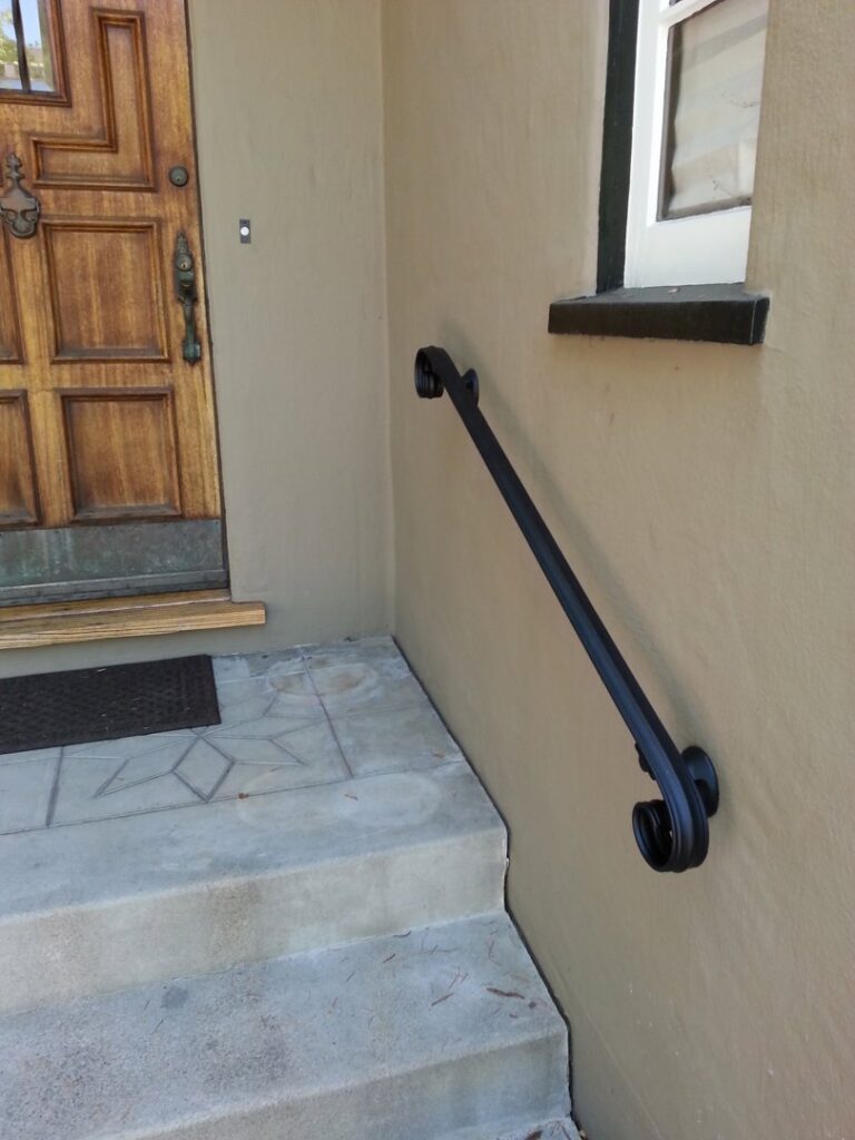 A decorative black wrought iron handrail installed on an exterior wall by Barry's Handyman Service in San Diego, CA.