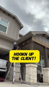 A worker on a ladder performing exterior home improvement installation for a client by TEXAN Home Improvements LLC in San Antonio, TX.