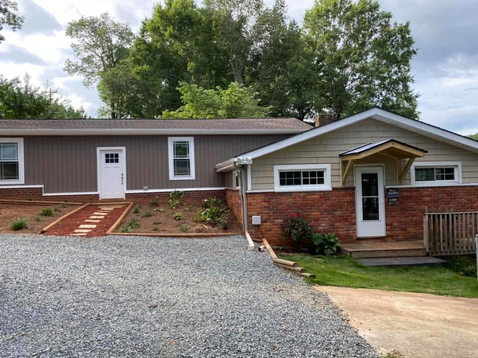 Exterior home renovation with new siding, landscaping, and a small porch by LDT Construction Services in Spring Hill, FL.
