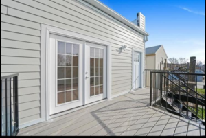 An exterior home renovation showing new siding, a spacious deck, and French doors by Revival Home Remodeling in Chicago, IL.
