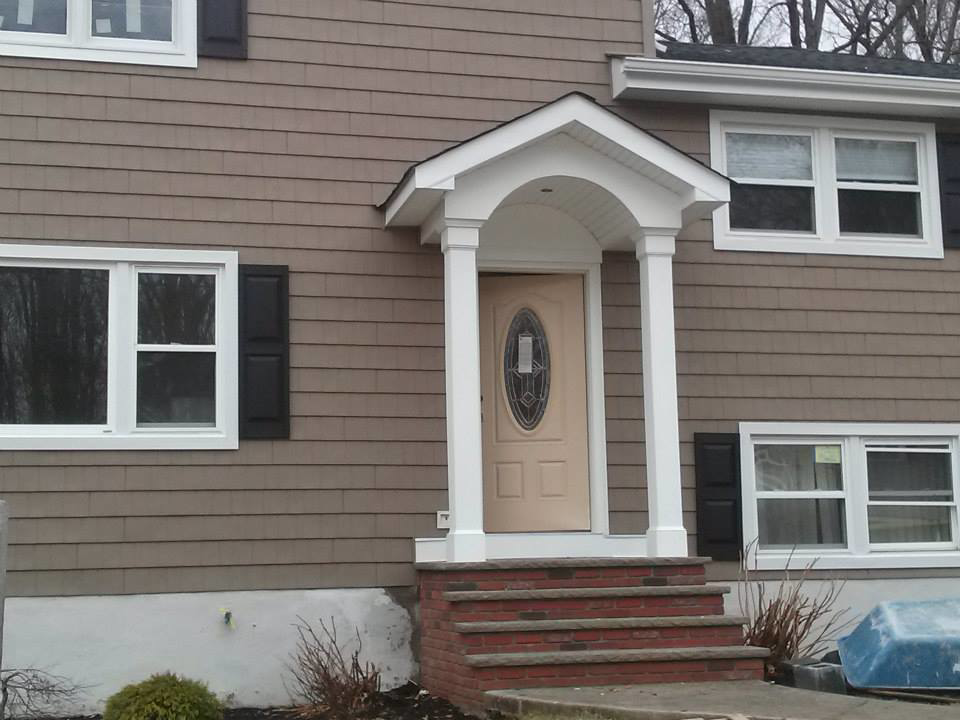 Completed exterior home renovation with new siding, windows, and porch by Allaico Construction in Elizabeth, NJ.