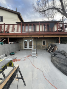 Exterior home renovation showing a newly installed double door and construction materials under a deck by JP Handyman Wyo in Sheridan, WY