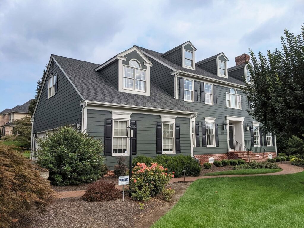 Exterior view of a home with new siding and trim completed by Roche Painting in Allentown, PA.