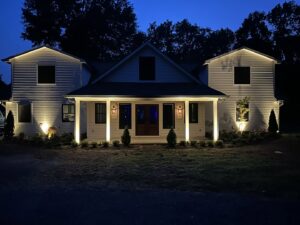 Exterior of a house at night with new landscape lighting installed by CMT Construction LLC in Columbia, MO.