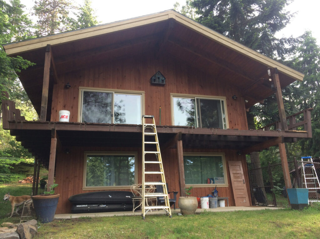 Exterior of a two-story wooden house with a ladder, indicating ongoing maintenance or deck work by Top Shelf Handyman Pros in Post Falls, ID