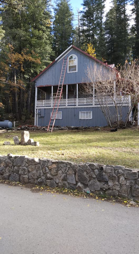 Exterior house maintenance with a ladder, performed by Handyman Heroes in Roswell, NM, for home improvement.