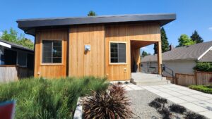 A blue house with newly painted siding and garage doors, showcasing exterior painting by Brush N' Roll Painting Co. in Federal Way, WA.