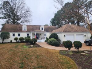 A beautifully painted light yellow house with white trim and a well-maintained lawn, a completed handyman painting project by Randy Overacre Painting Company in Virginia Beach, VA.