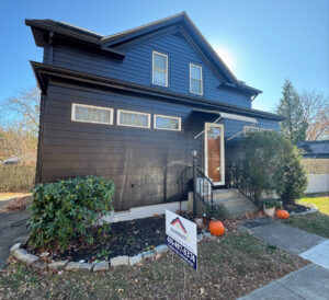 The exterior of a house with newly painted dark siding, showcasing a completed painting project by Quinonez Painting & Renovations LLC in Providence, RI.