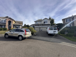 Exterior house painting in progress with ladders and a work van by J&R Buezo Painting Services LLC in Everett, WA