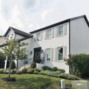Exterior view of a newly painted white brick house with dark trim, a project completed by Prestige Remodeling Solutions in Antioch, TN