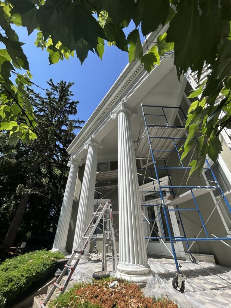 Exterior house painting in progress with scaffolding and ladders by Tribute Painting & Drywall in St. Louis, MO.
