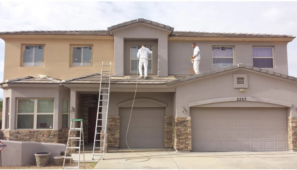Two workers on ladders painting the exterior of a house by Paint Co in Canyon Lake, CA