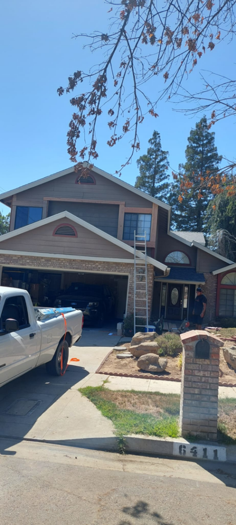 An exterior house renovation project with a ladder leaning against the siding, performed by Montano's Handyman in Fresno, CA