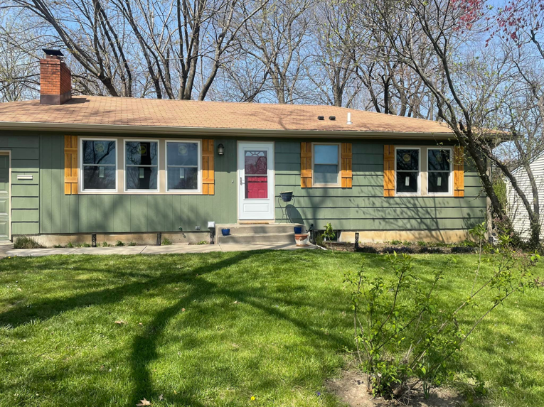 Exterior of a house with new windows and decorative shutters installed by Norbe's Home Solutions LLC in Lenexa, KS.