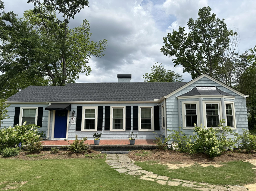 A freshly renovated house exterior with new roofing and siding by Parker Painting Company in Edmond, OK.