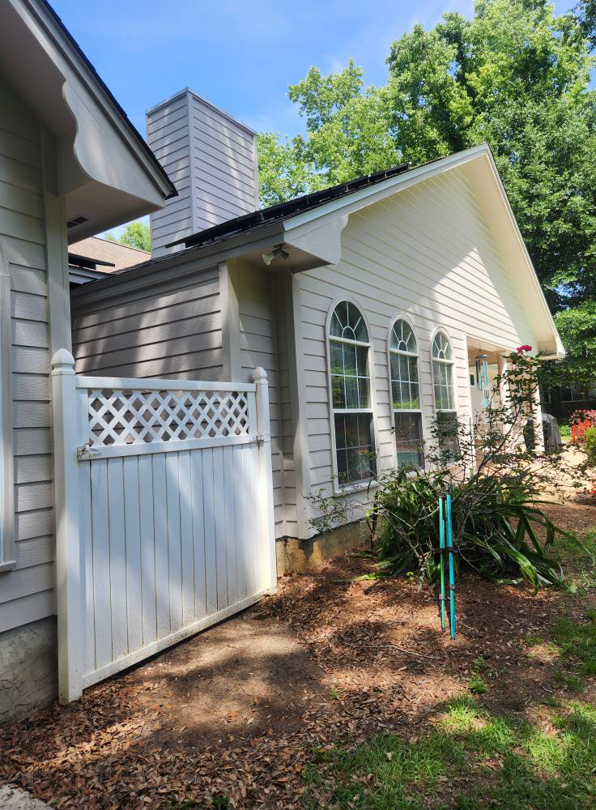 Exterior house siding painting on a beige home with white trim and arched windows by Oseguera Painting, LLC in Tallahassee, FL