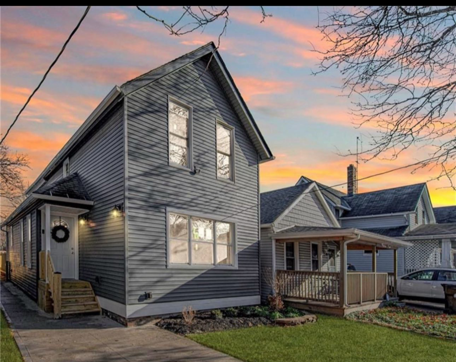 An exterior house renovation featuring new gray siding and updated windows completed by JC Remodeling Ro LLC in Cleveland, OH.