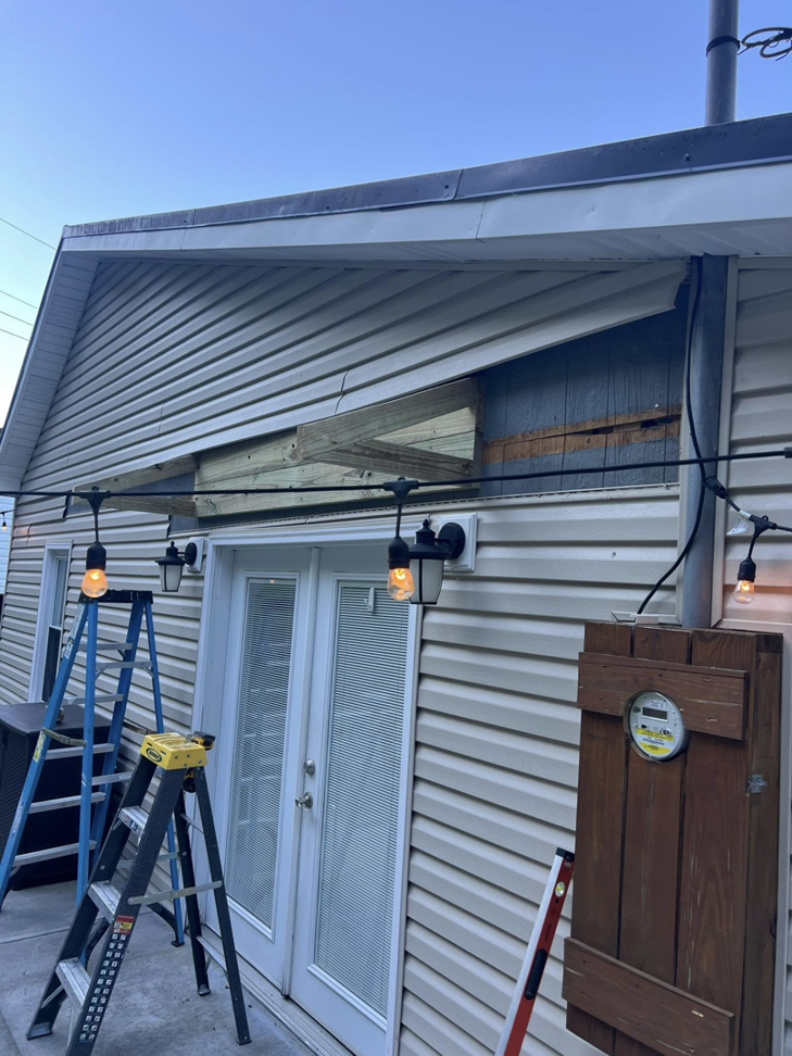 Exterior house siding repair in progress with exposed framing and ladders by Home Changes in Knoxville, TN