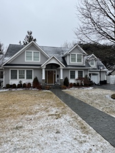 The exterior of a well-maintained house with a light dusting of snow, showcasing home improvements by Tarr's Home Improvements in Franklin Square, NY.